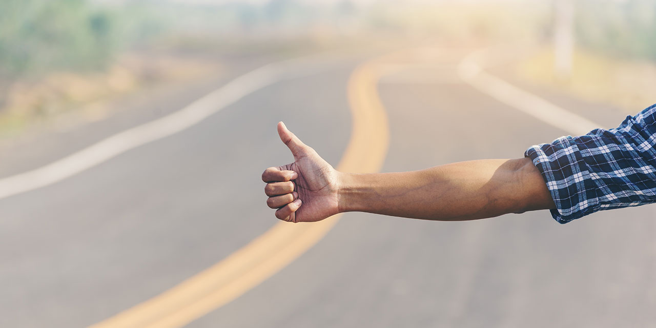 Hitchhiker thumbs up road